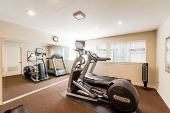 a gym with two treadmills and other exercise equipment